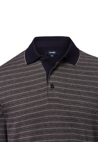 Granatowa koszulka polo w paski z prążkowanym kołnierzykiem, trzema guzikami i beżowymi poziomymi paskami. Tkanina ma teksturowany wygląd.
