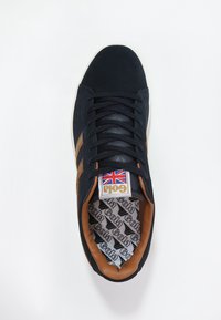 Sneaker navy con strisce marroni, tomaia in tessuto e suola in gomma. Presenta un'etichetta con il logo della Union Jack e una fodera interna a motivo. Design con lacci.