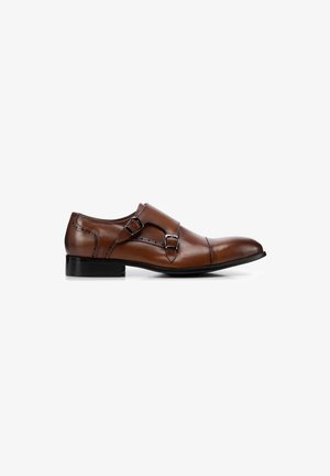 Zapato de vestir de cuero marrón con diseño de doble hebilla, puntera redonda, suela negra y detalles de costura. Textura suave y silueta elegante.