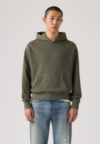 Πράσινο ελαιολαδί φούτερ με κουκούλα από βαμβάκι, με εμπρόσθια τσέπη και ριμπ μανσέτες. Διακριτικό λογότυπο γνωστής μάρκας σε διακριτό τύπωμα.