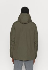 Olive green, hooded jacket featuring a smooth, matte finish, and slightly tapered design, ending just below the waist.
