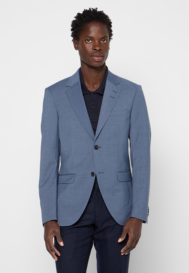 Helles blaues Blazer mit Revers, zwei Vordersektoren und Zwei-Knopf-Verschluss. Der Stoff hat eine strukturierte Webart. Kombiniert mit einem dunklen Poloshirt.