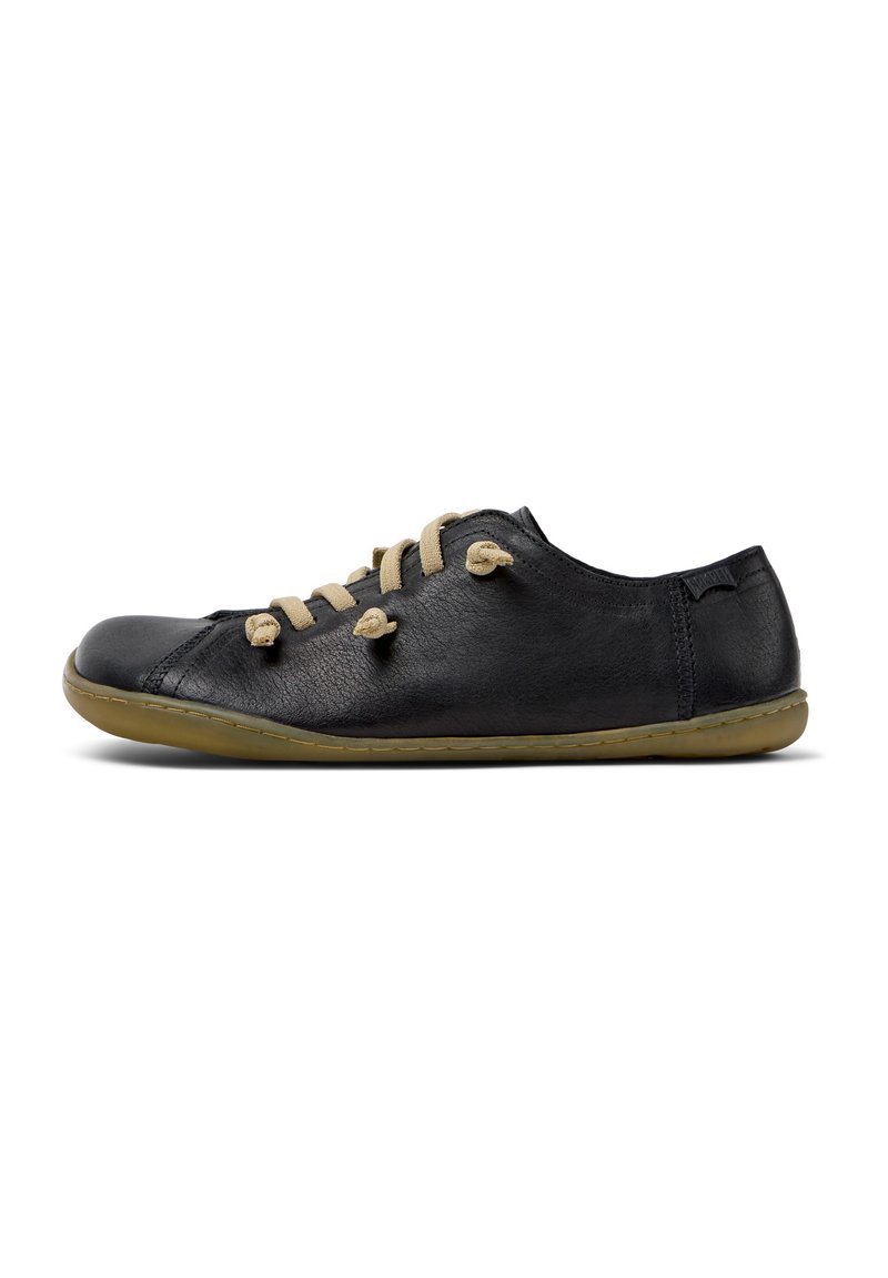 Black leather shoe with beige laces, rounded toe, flexible sole, and minimal stitching. Designed for comfort with a casual, flat silhouette.