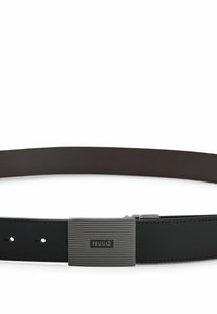Ceinture en cuir noir dotée d'une boucle métallique ribbed horizontale avec un logo. La ceinture possède des trous ajustables et une texture lisse.