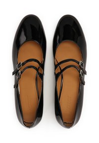 Black patent leather Mary Jane shoes with two adjustable straps, rounded toe, and a tan insole. Smooth texture with shiny finish.