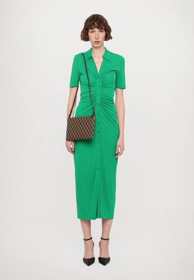 Green jersey midi dress with short sleeves, ruching at the waist, and button front. Paired with a brown patterned crossbody bag and black heels.