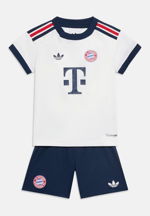 Maglia e pantaloncini da calcio per bambini del FC Bayern Monaco bianchi e blu navy con strisce rosse e nere e loghi degli sponsor.