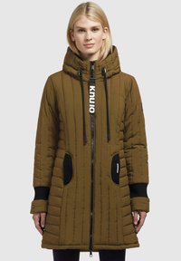 Giacca parka imbottita marrone con cappuccio, caratterizzata da trapuntatura verticale, dettagli neri, chiusura con zip e due tasche laterali.