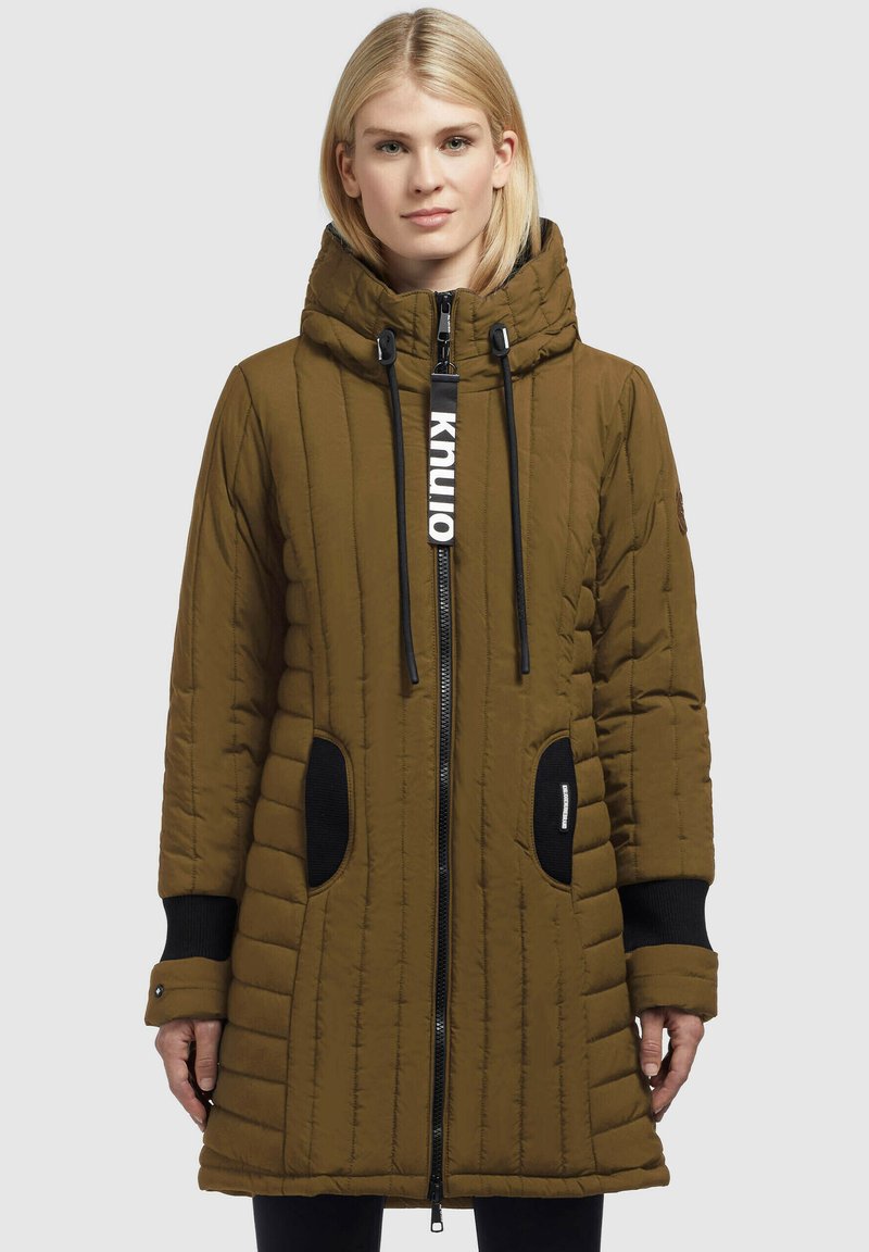 Giacca parka imbottita marrone con cappuccio, caratterizzata da trapuntatura verticale, dettagli neri, chiusura con zip e due tasche laterali.