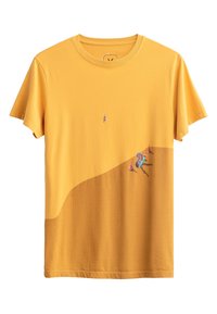 Gele katoenen t-shirt met een ronde hals, voorzien van een geborduurd ontwerp van een vogel en een persoon die bij kegels zit aan de onderkant.