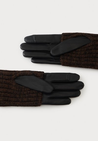 Paire de gants en cuir noir avec poignets en tricot marron foncé posée à plat, montrant le recto et le verso.