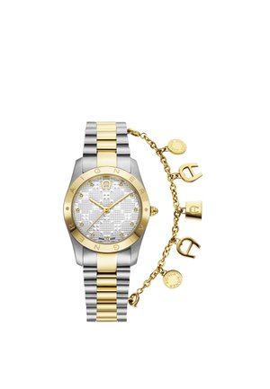 Reloj de pulsera bicolor en plata y oro con esfera decorada y colgantes dorados sujetos por una cadena en el lateral.