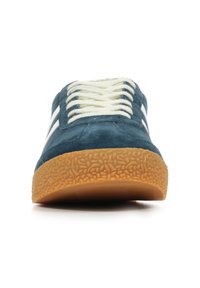 Sneaker in camoscio blu con lacci e strisce bianche. Suola in gomma testurizzata. Il design a profilo basso presenta una punta arrotondata e una costruzione robusta.