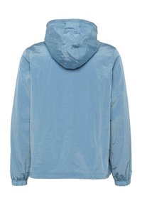 Světle modrá bunda s kapucí, lesklým povrchem, elastickými manžetami a volným střihem. Tkanina vypadá hladce bez viditelných vzorů nebo akcentů.