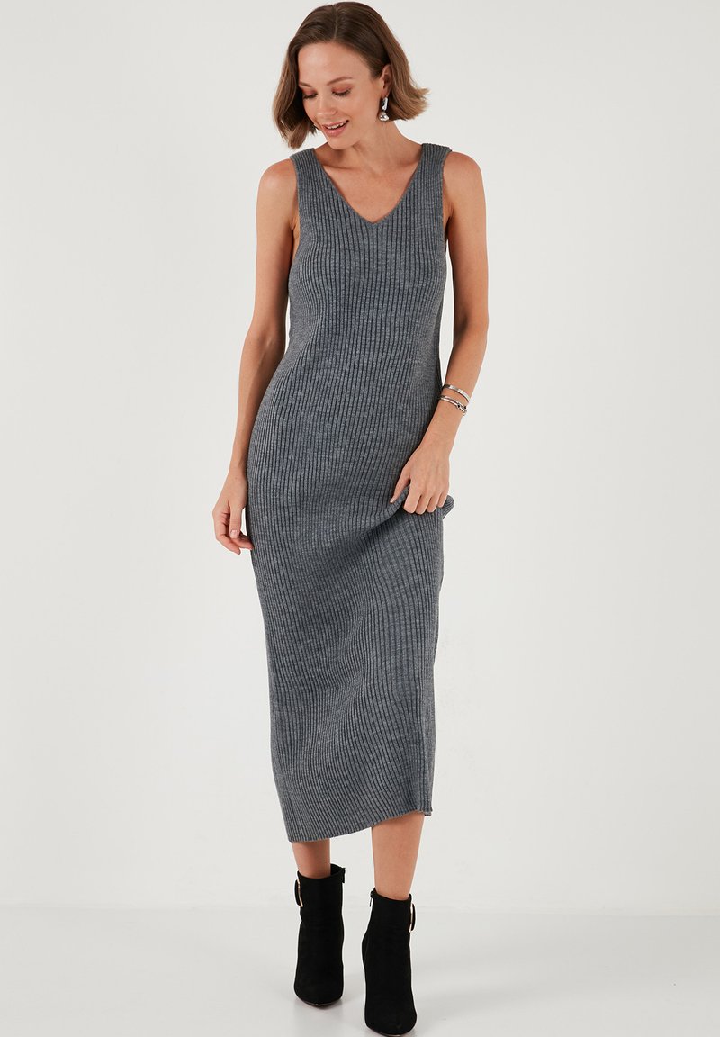 Gray ribbed knit midi dress with a V-neck, sleeveless design, and a fitted silhouette, paired with ankle boots. Smooth textured fabric.