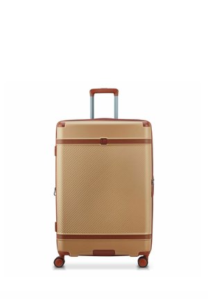 Valigia rigida con ruote beige con rifiniture marroni e manico telescopico, mostrata in posizione verticale su quattro ruote girevoli.