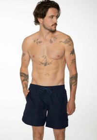 Shorts de bain bleu marine avec une taille élastique et un cordon de serrage ajustable, dotés de poches latérales et d'un détail de logo sur l'ourlet.