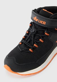 Sapatilha de cano alto preta e laranja com atacadores elásticos, faixa de Velcro e sola texturizada para uso ao ar livre ou desportivo.
