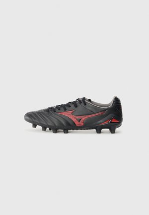 Black football cleat with red accents, textured leather upper, six studded outsole, padded collar, and prominent logo design on the side.