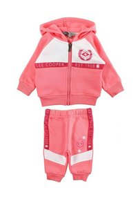 Ensemble de jogging en coton rose comprenant une veste à capuche zippée avec des accents blancs et un pantalon assorti à taille élastique avec des détails de logo.