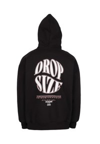 Felpa nera con cappuccio, con grande testo stilizzato bianco e rosa "DROP SIZE" sulla schiena, testo più piccolo sotto, indossata con il cappuccio alzato, mostrata su sfondo bianco.