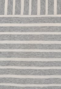 Grå och vit randig tyg med växlande enfärgade och texturerade linjer, som ger en mjuk, stickad struktur med ett regelbundet mönster.