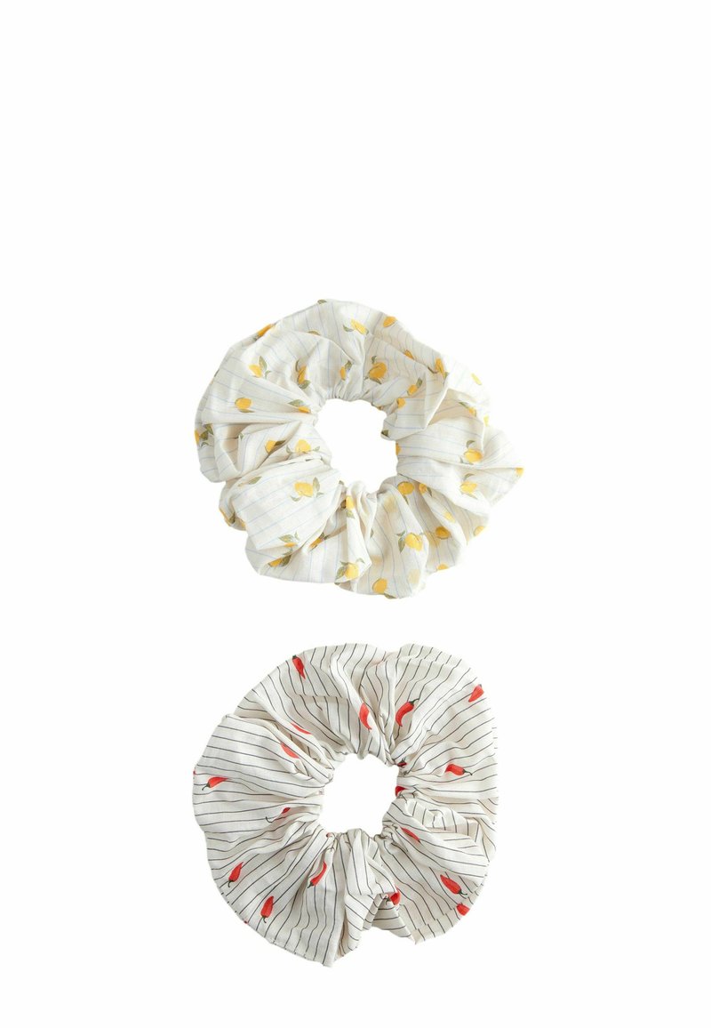 Divi audumi scrunchies: augšējais ir balts ar dzeltenu augļu rakstu, apakšējais ir balts ar melniem svītrām un sarkanām asaru formām. Mīksta tekstūra.
