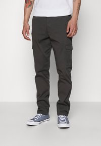 Pantaloni cargo grigi in tessuto leggero, con tasche laterali e design a gamba dritta, abbinati a sneakers blu.