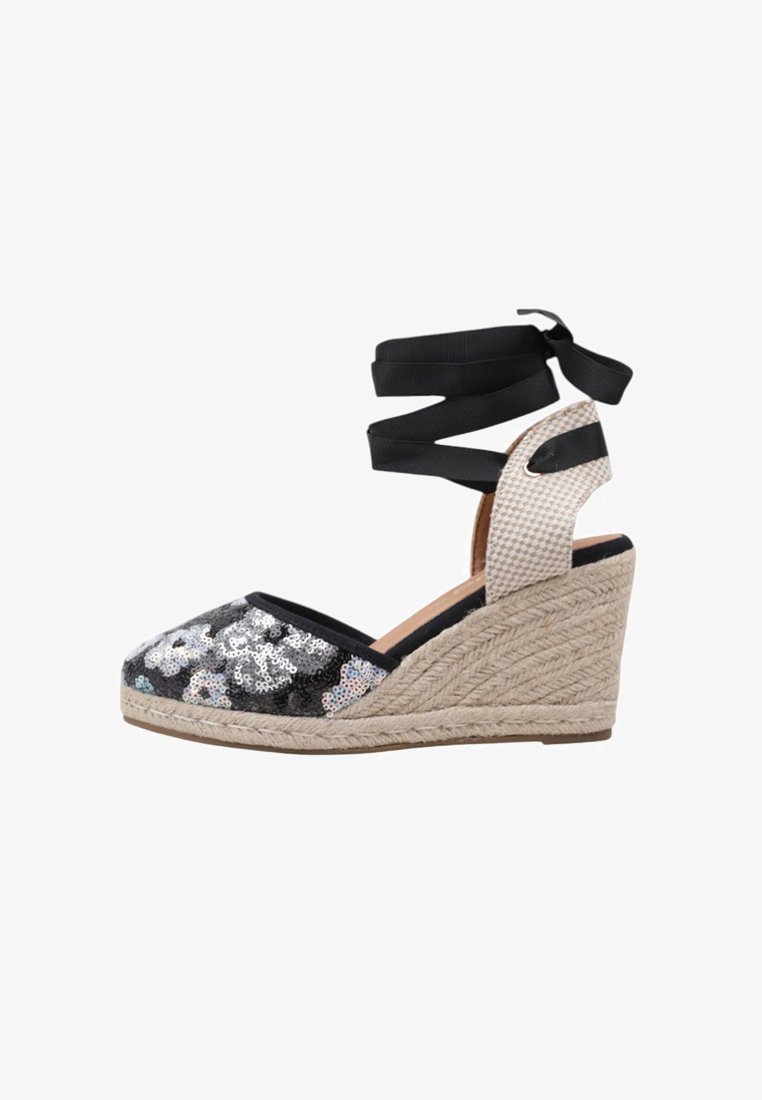 Espadrilles de cuña con un upper de lentejuelas negras que presenta patrones florales, tacón de yute beige y cintas negras para envolver el tobillo.