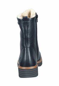 Botas de tobillo de cuero negro con un acabado texturizado, forro beige suave en la parte superior y un tacón apilado. Cremallera lateral para ponerlas y quitarlas con facilidad.