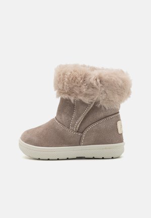 Bota corta para niños de ante color topo con puño de piel suave y suela de goma blanca, mostrada desde un lateral sobre un fondo liso.