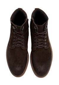 Brązowe zamszowe botki za kostkę z metalowymi oczkami, brązowymi sznurówkami, wyściełanym kołnierzem i kontrastującą jasnobrązową podeszwą. Gładka faktura w całej powierzchni.