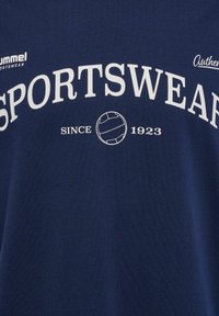 Mörkblå bomulls t-shirt med stor vit text "SPORTSWEAR" och en volleyboll-graphic. Har "sedan 1923" i mindre text under.