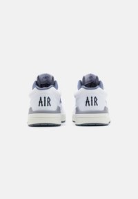 Ein Paar weiße und graue Sneakers mit dem Schriftzug "AIR" auf der Ferse, von hinten vor einem schlichten weißen Hintergrund gezeigt.