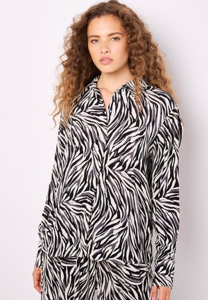 Schwarz-weißer Zebra-Print-Hemd mit Kragen, langen Ärmeln und einem leichten, glatten Stoff.