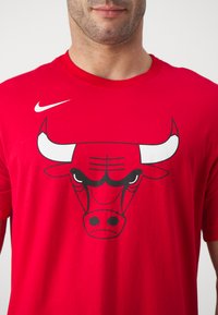 Rød bomulds t-shirt med et stort sort-hvidt okse grafik på forsiden, med et hvidt Nike-logo på venstre skulder.