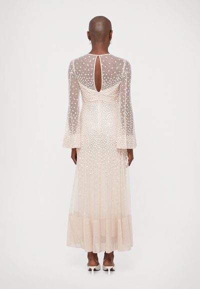 Duga, ružičasta večernja haljina s prozirnim, zvonastim rukavima, točkastom teksturom, otvorenim leđima i lepršavom suknjom, s horizontalnim nabranim detaljima i patentnim zatvaračem.