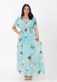 Maxiklänning i ljusblått med blommönster, korta puffärmar, rynkad midja, flödande kjol och mjukt, lätt tyg.