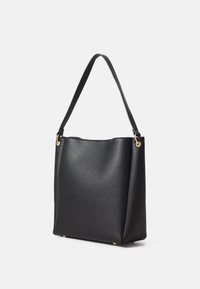 Sac fourre-tout en cuir noir avec une surface texturée, une forme plate, des accents en métal doré et une seule bandoulière incurvée.