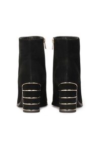 Stivaletti neri in suede con chiusura a zip, caratterizzati da un distintivo accento dorato su un tacco impilato con tre bande orizzontali.