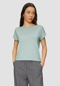 Lichtblauwe t-shirt met korte mouwen en een losse pasvorm, voorzien van opgerolde mouwen en een zachte, gladde textuur, gecombineerd met grijze broek met elastische taille.