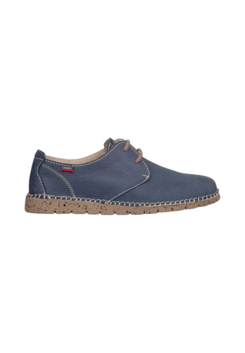 Zapato de cuero azul marino casual con suela texturizada beige, cordones beige, costuras blancas y una pequeña etiqueta de marca cerca del talón.