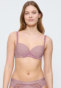Bra i mjuk mauve med släta kupor och blommig spetsdetalj. Har justerbara band och subtila, vågiga kanter för designens skull.
