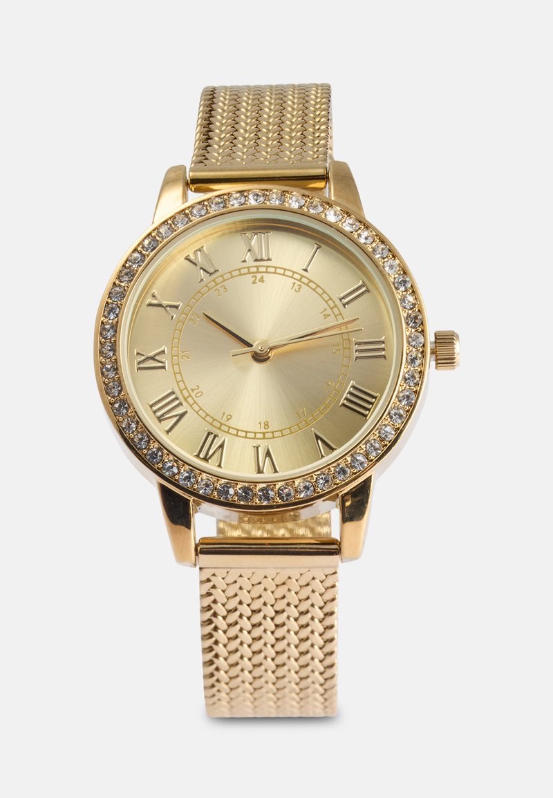 Gold wristwatch featuring a round face with Roman numerals, a textured gold mesh band, and a crystal-accented bezel.