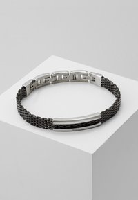 Bracciale in metallo con una combinazione di finiture opache e lucide, caratterizzato da un design a catena intrecciata in argento e nero. Accentato da due eleganti barre in metallo.