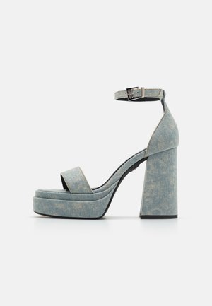 Denim platform sandalen met een dikke blokhak, open teen en enkelband met een metalen gesp. Lichtblauw met subtiele textuur.