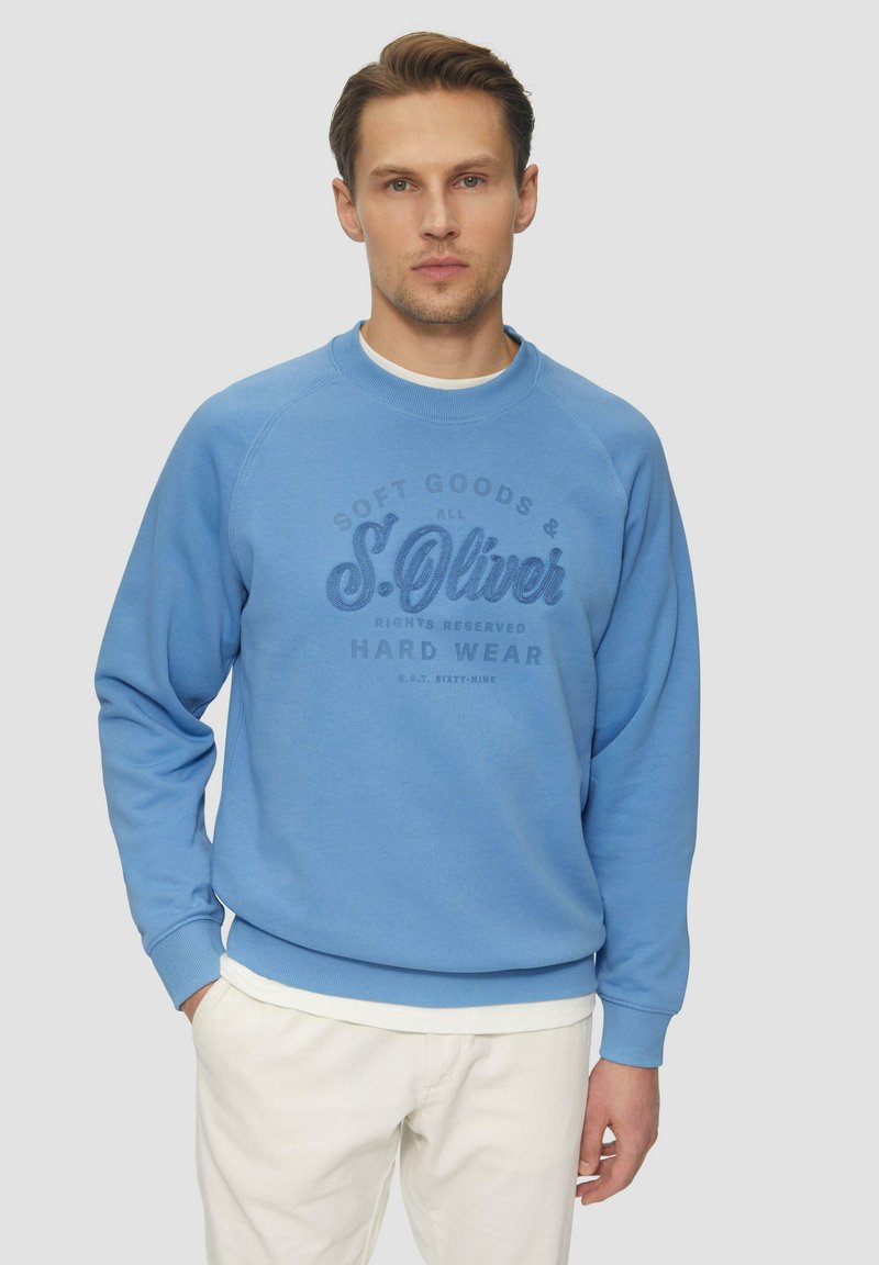 Sudadera azul claro hecha de material suave que presenta un cuello redondo, puños acanalados y un estampado de logo texturizado en un azul más oscuro.