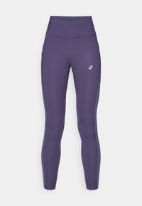 Fialové sportovní legíny vyrobené z elastického materiálu s vysokým pasem a bočními kapsami. Obsahují logo na spodní části přední části. Hladká textura.
