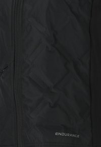 Schwarze Jacke mit Rautenmuster, Reißverschluss und "ENDURANCE"-Logo. Das Material scheint wasserabweisend und hat eine glatte Textur.