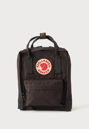 Sac à dos Fjällräven Kånken noir avec poche zippée à l'avant et logo rouge avec un renard et le nom de la marque sur fond blanc.